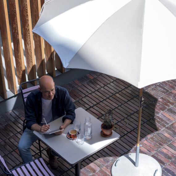 Pourquoi les données dans le cloud ont aussi besoin d'une sauvegarde (homme assis à l'abri d'un parasol)