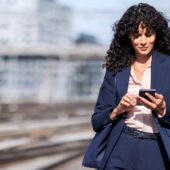 Geschäftsfrau mit Smartphone: 5 Tipps zur mobilen Zusammenarbeit in KMU