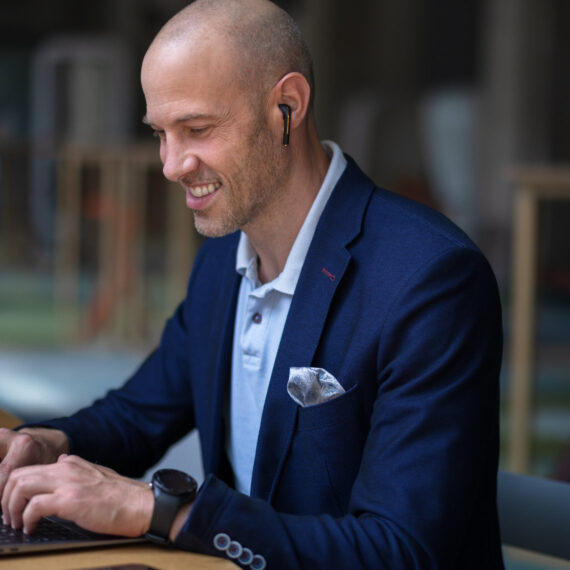 Modernes Arbeiten in der Versicherungsbranche: Mann sitzt am Notebook.