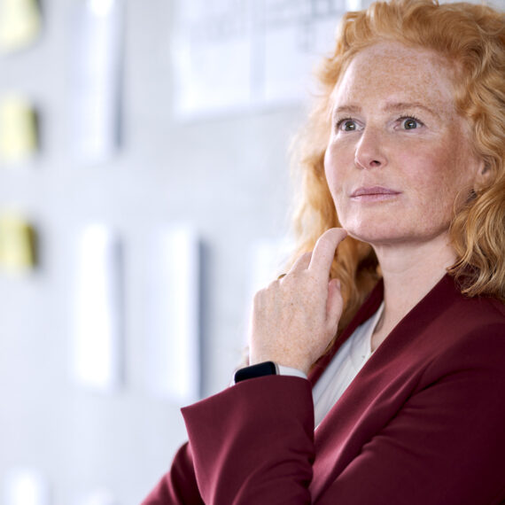 Wie KMU Windows 10 ablösen können (Frau mit nachdenklichem Blick lehnt an Wand)